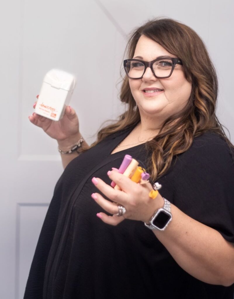 Lisa, hair stylist, holding beauty products.